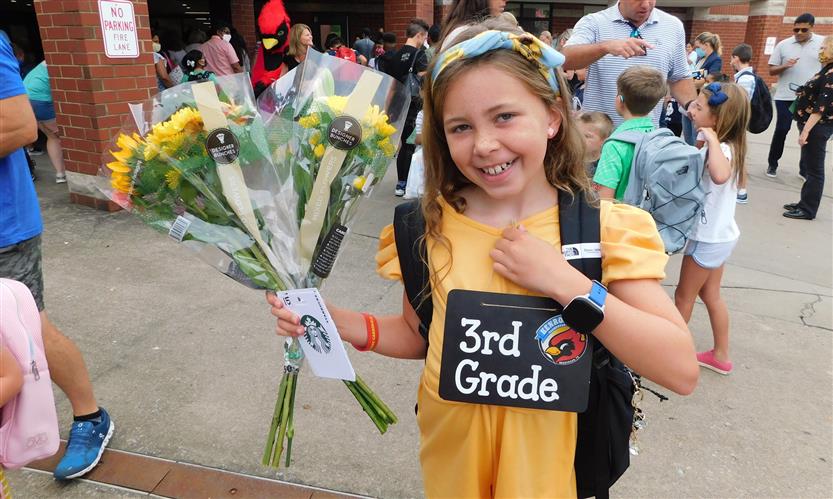 A student holds a bouquet of flowers